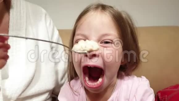 一个女人在厨房里给一个小女孩喂燕麦片视频的预览图