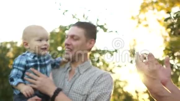 爷爷儿子和孙子在苹果园玩得很开心一个年轻人抱着他的小儿子视频的预览图