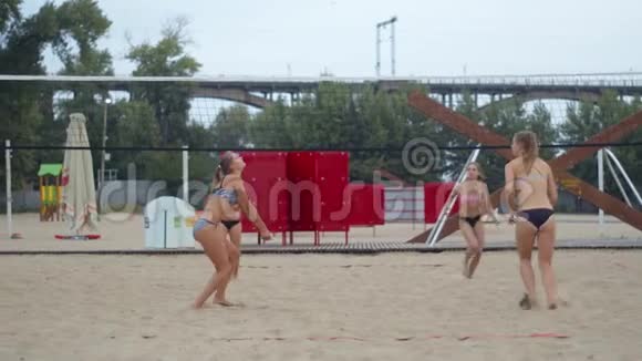 四名年轻女子在沙滩上打排球的慢镜头4k视频的预览图