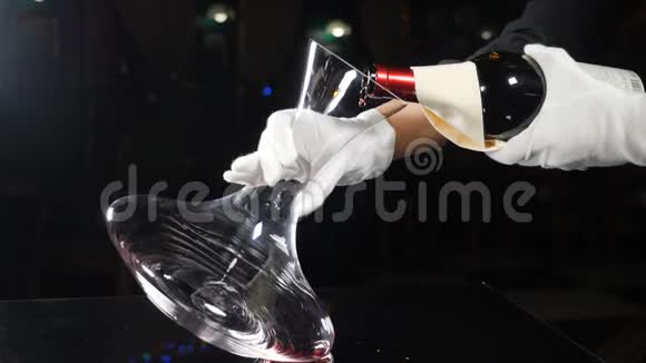熟练的侍酒师把红酒从瓶子里倒进酒壶餐厅的葡萄酒酿造过程关闭手举起来视频的预览图