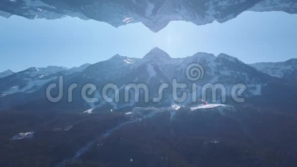 具有镜面反射效果的雪山令人叹为观止的景观剪辑冬天森林覆盖的高山视频的预览图