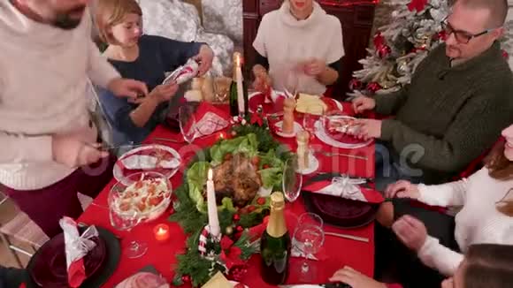 家人团聚在圣诞餐桌旁父亲切火鸡视频的预览图