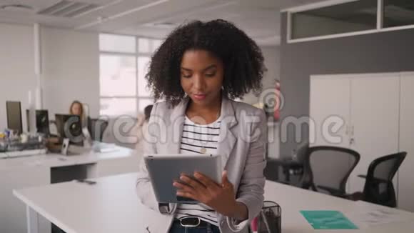 自信的年轻非洲女商人在办公室同事面前使用数码平板电脑视频的预览图