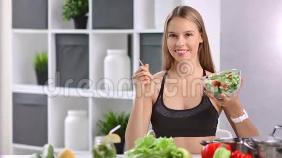 健身妇女的肖像摆着一碗新鲜可口的蔬菜和厨房叉子视频的预览图