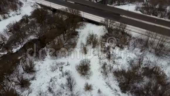 冬天的交通汽车在冬季的道路上用雪覆盖的树木鸟瞰视频的预览图