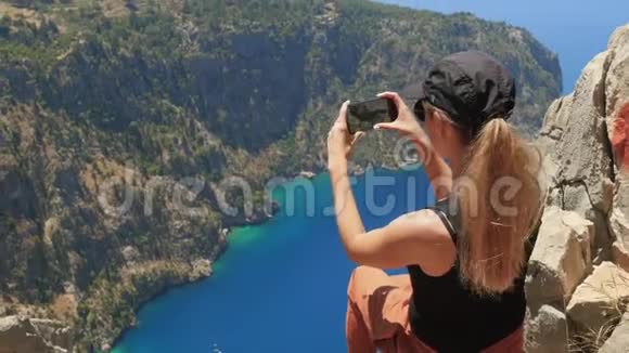 女旅行者拍照或录像从山顶欣赏美丽的蝴蝶谷视频的预览图