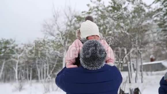 父亲在下雪的冬天把他可爱的女儿抛在空中父母把他的孩子扔上去然后抓住视频的预览图