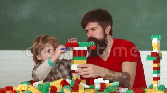 父亲和小儿子在车间用钻穿木板孩子和父亲在家玩建筑小可爱视频的预览图