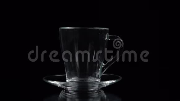 在一杯茶杯中倒入一部分茶慢动作放在黑色背景上视频的预览图