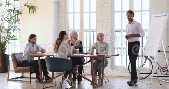 自信的男性营销专家在办公室小组会议上发言视频的预览图