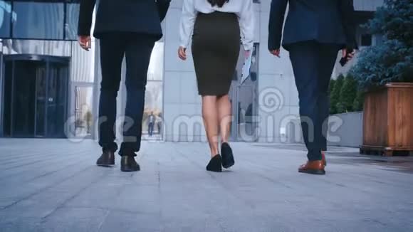 三位成功商务人士往返办公大楼的后后景脚商人和商人视频的预览图