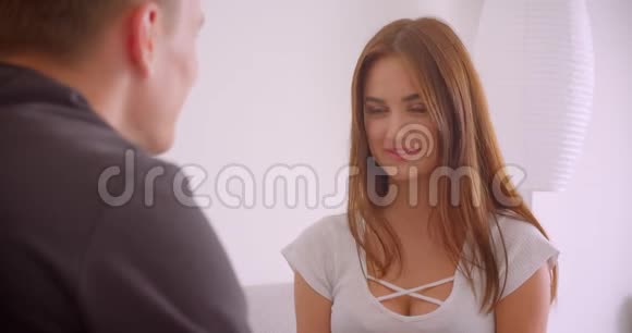 一对年轻可爱的白种人夫妇手牵手坐在公寓的特写镜头女人开心地说视频的预览图