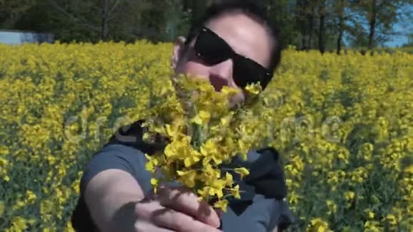 带着黄色油菜花的油菜田上的女人花粉过敏的概念视频的预览图