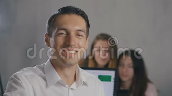 年轻男队长的肖像带着笑脸在办公室背景是人队专业经理视频的预览图