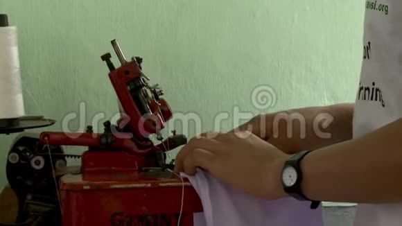 当地一名工人在缝纫机上喂布视频的预览图