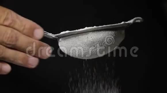 通过筛子磨碎面粉筛面粉烘焙黑色背景视频的预览图