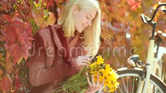 秋天和树叶飘落的梦想秋天的女人在公园里玩得很开心笑着穿着针织毛衣留长发的梦幻女孩视频的预览图