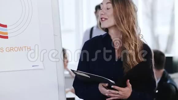 年轻快乐的白种人CEO商务女性带着公文包在办公室会议上向同事解释财务图表视频的预览图