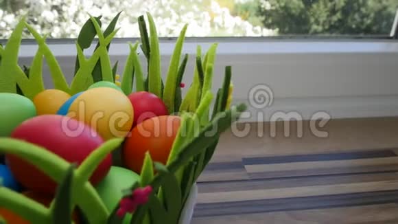 五颜六色的复活节彩蛋放在厨房窗户旁漂亮的篮子里视频的预览图