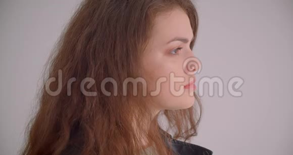 漂亮的黑发女孩穿着皮夹克把梦幻般的手表放在白色背景上的摄像机里视频的预览图
