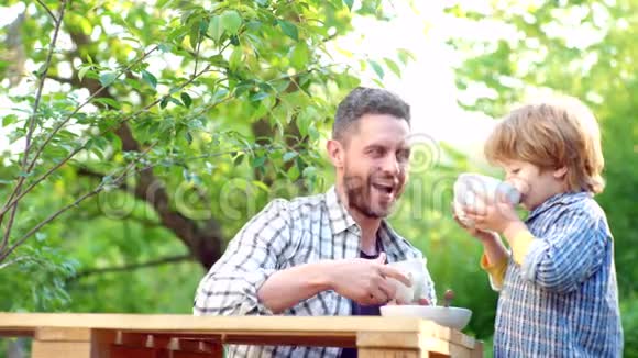 有孩子的父母春天的时候夏季配给可爱的孩子在花园里家吃早餐儿童概念生态生活视频的预览图