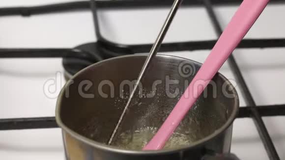 一个人把温度计放在糖浆里测量它的温度糖浆在炖锅里煮准备棉花糖可见厚视频的预览图