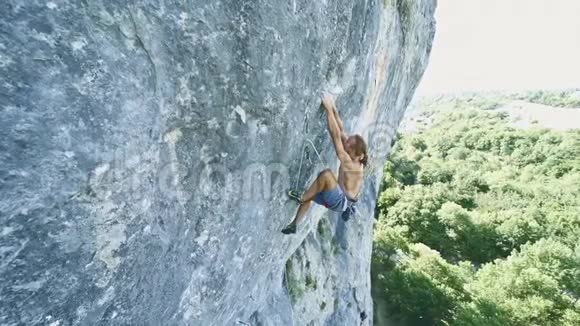 攀岩者在垂直个垂直的悬崖上进行动态的攀爬并进行了艰难的宽移和视频的预览图