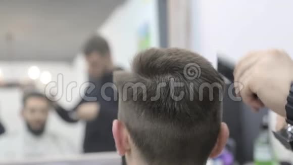 理发师用剪刀把顾客头发剪在椅子上特写剪头剪去头发视频的预览图
