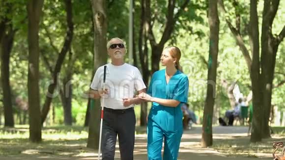 护士与老盲人一起沿临终关怀公园物业护理及支援视频的预览图