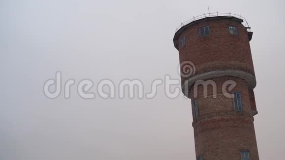 冬季红砖水塔在阴沉的天气下农村的老高塔视频的预览图