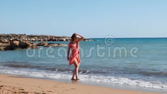 年轻迷人的女孩沿着沙滩散步布鲁内特女孩在海滨玩得很开心女孩在海边晒太阳女孩放松视频的预览图