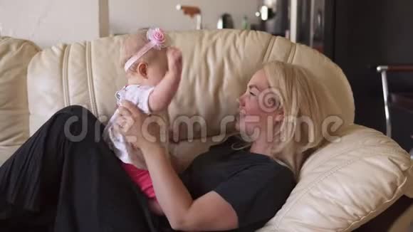 可爱的女婴在沙发上和妈妈玩视频的预览图