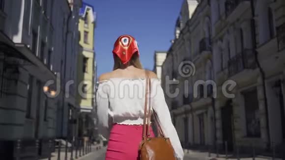 积极的美丽的年轻女子走在街上转过身来看着相机做着诱人的手势视频的预览图