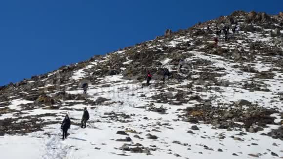 一群疲惫的登山者在冬天从雪山上下来长期射击视频的预览图