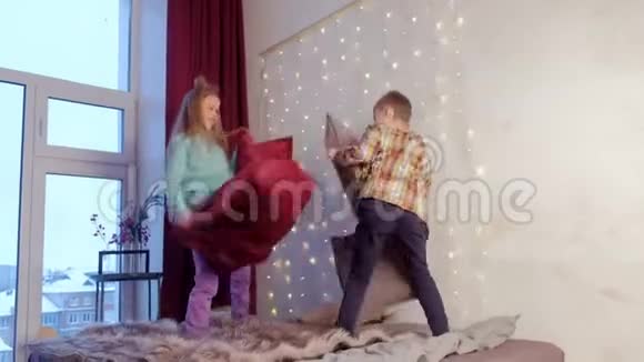 孩子们孩子男孩和女孩在卧室里打架枕头在圣诞节假期视频的预览图