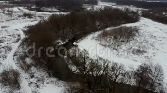 在寒冷的冬日里平静的河水和寒冷的灰色的冬季乡村视频的预览图