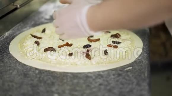 手工制作的一个把黑橄榄放在奶酪披萨生面团上的镜头视频的预览图