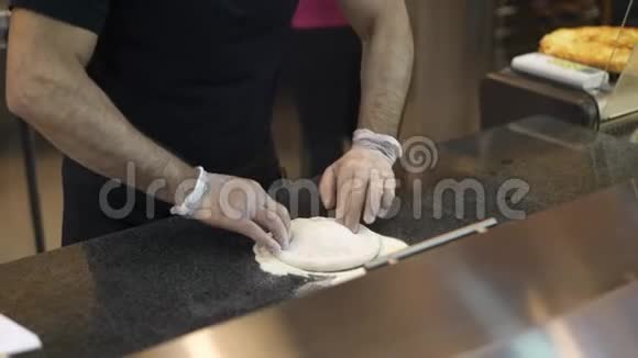 中档厨师手戴手套揉碎面团视频的预览图