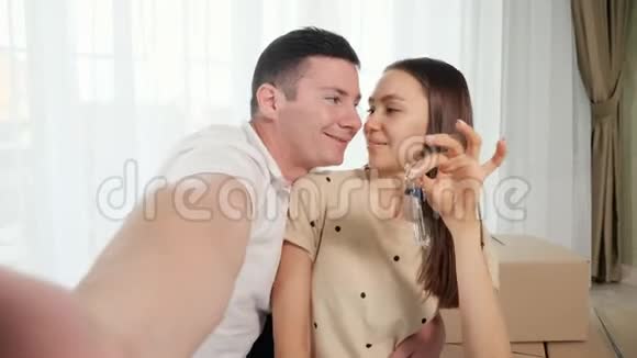 幸福的一对情侣用钥匙拍一张新房子视频的预览图