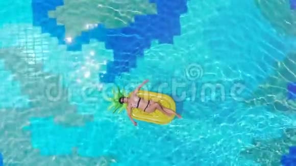 一个女孩躺在游泳池里的橡胶床垫上海上豪华度假概念视频的预览图