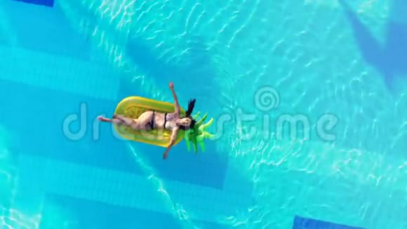 一个人在游泳池里休息漂浮在橡胶床垫上泳池里的无忧无虑的女人视频的预览图