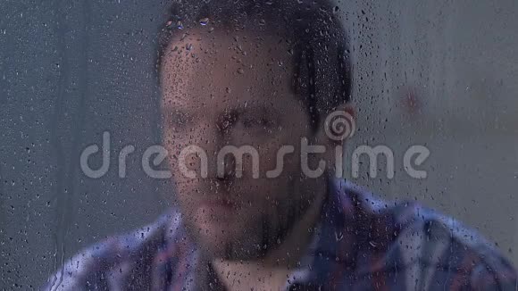 男人用手掌在雨窗后绝望地闭上脸烦恼视频的预览图