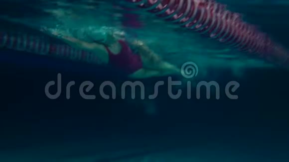 鳄鱼游泳运动员在游泳池里练习女游泳运动员练习翻转水下视野夜间射击视频的预览图