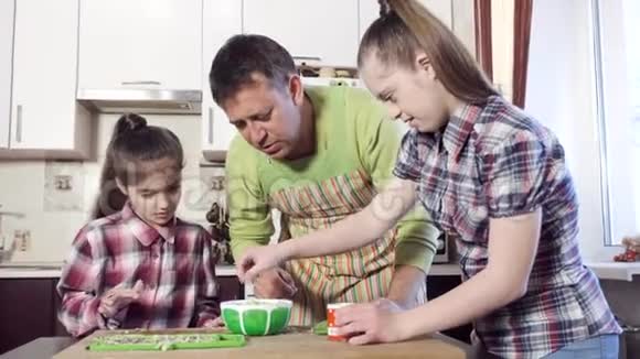 厨房里的父亲和女儿准备绿色沙拉视频的预览图
