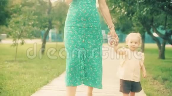 夏天一个快乐的小女孩和妈妈一起在公园散步视频的预览图