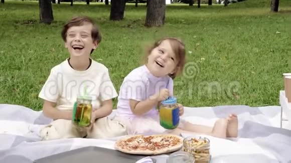 两个可爱的小孩在户外玩喝饮料视频的预览图