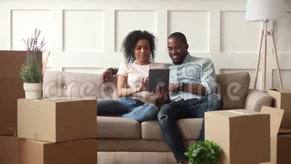快乐的非洲夫妇在搬家当天使用数码平板电脑视频的预览图