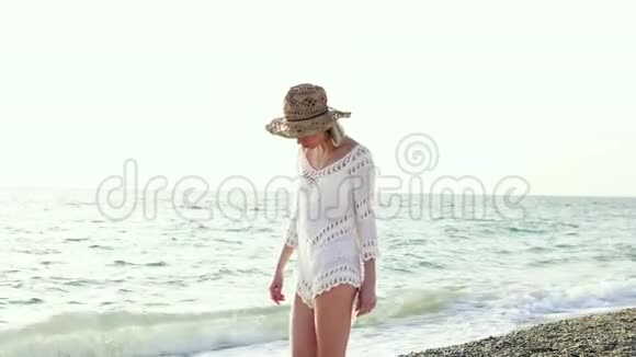 穿比基尼和草帽躺在沙滩上的女人视频的预览图