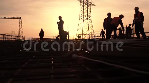 在美丽的日落背景下施工现场的工人剪影视频的预览图