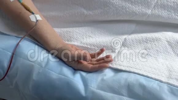 无助的病人躺在病床上的手手臂上的滴管垂死的人视频的预览图